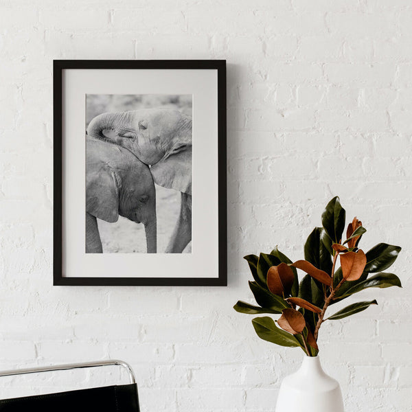 Framed "Brotherly Love" print on white brick wall